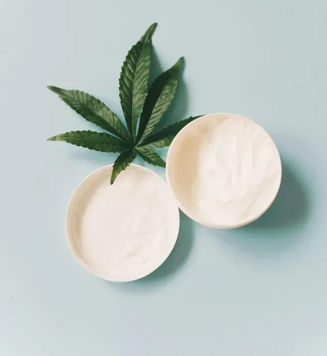 A person is holding a bottle of oil with a pipette in their hand.