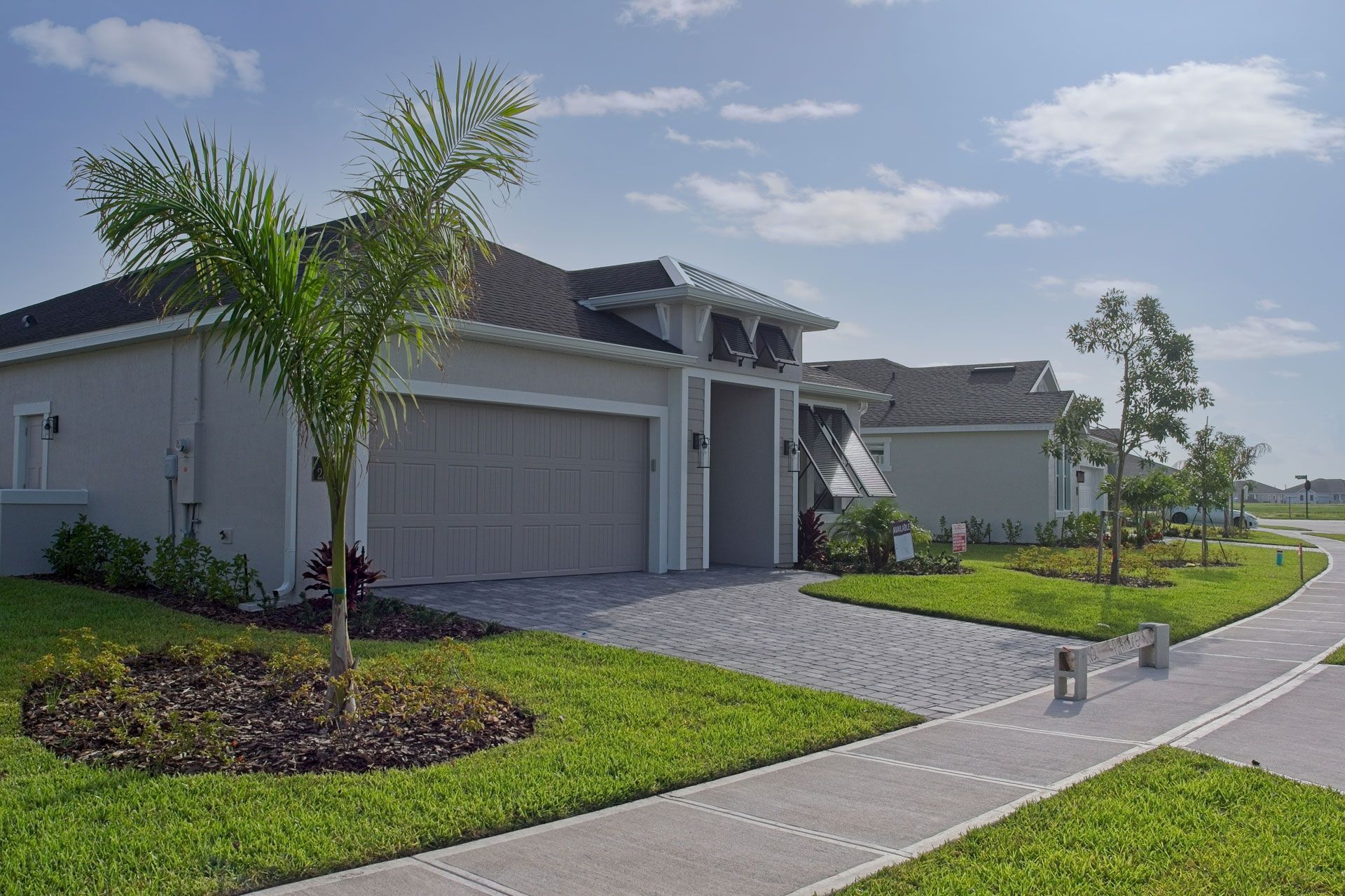 A house with a garage and a palm tree in front of it