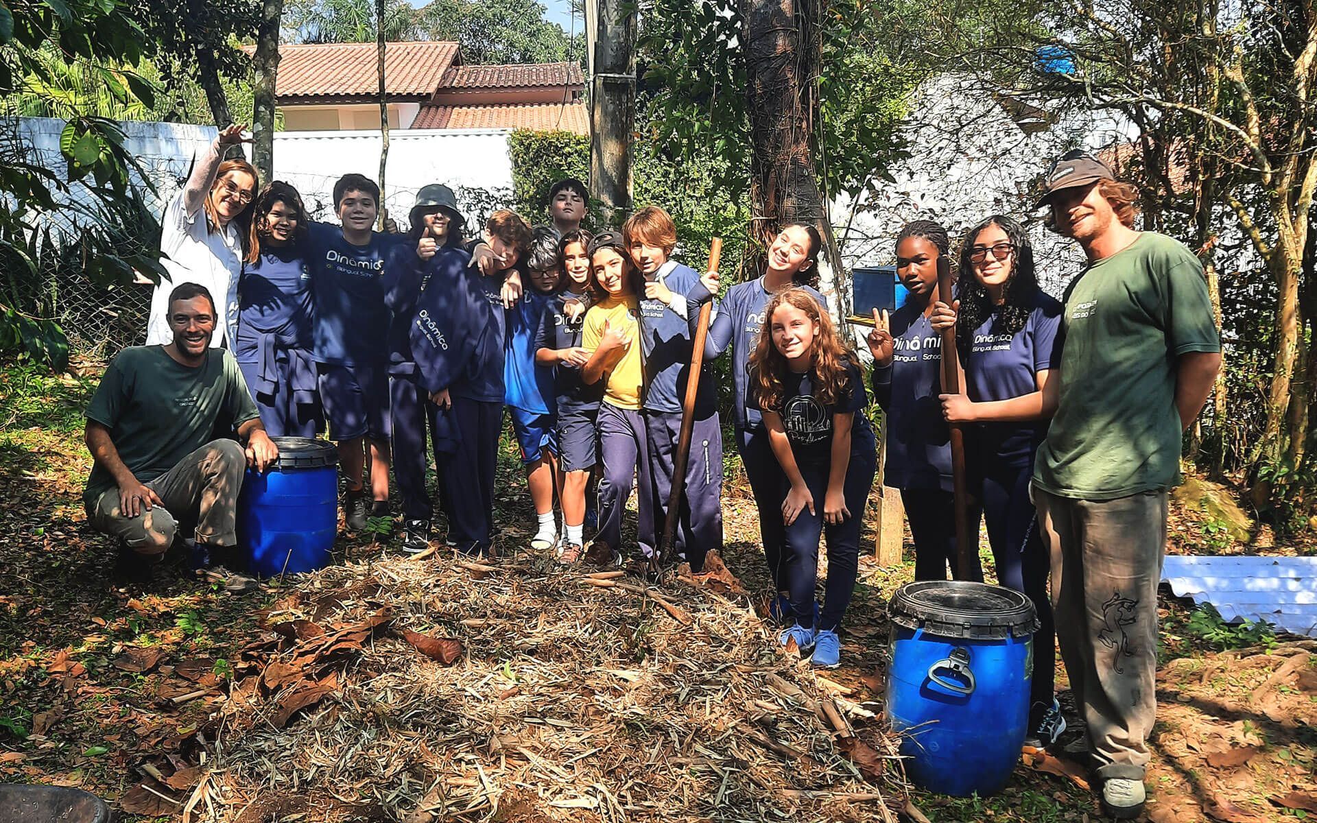 Alunos e professores em aula prática de compostagem