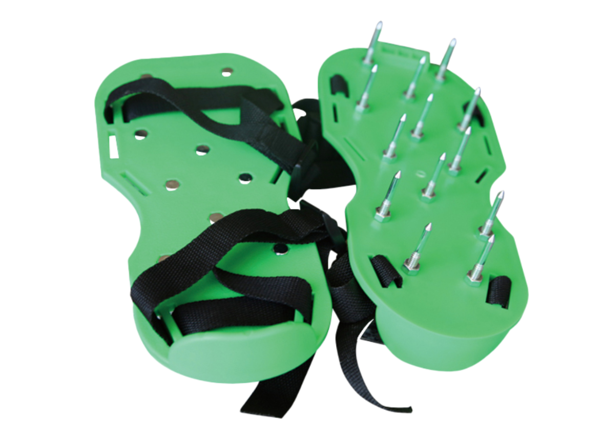Green lawn aeration shoes with black straps and metal spikes.