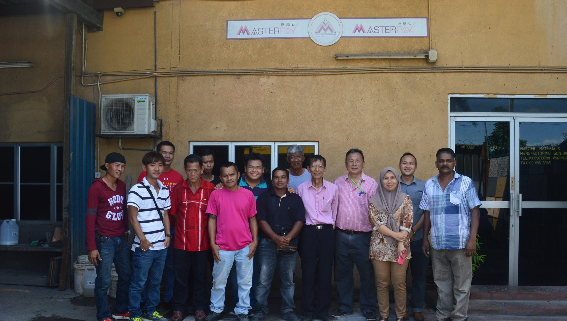 Group of people standing outside a building with a sign that says 