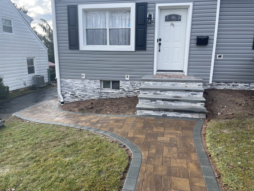 A brick walkway leading to the front steps of a house.