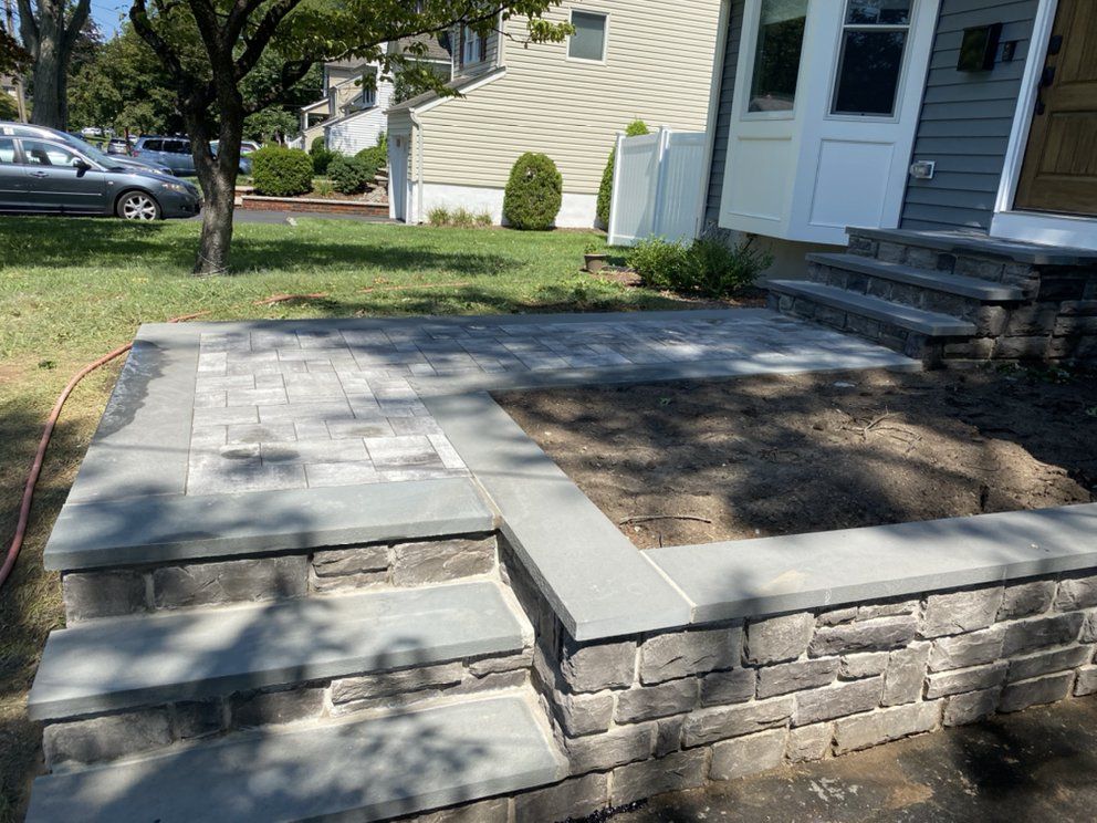 A stone walkway is being built in front of a house.
