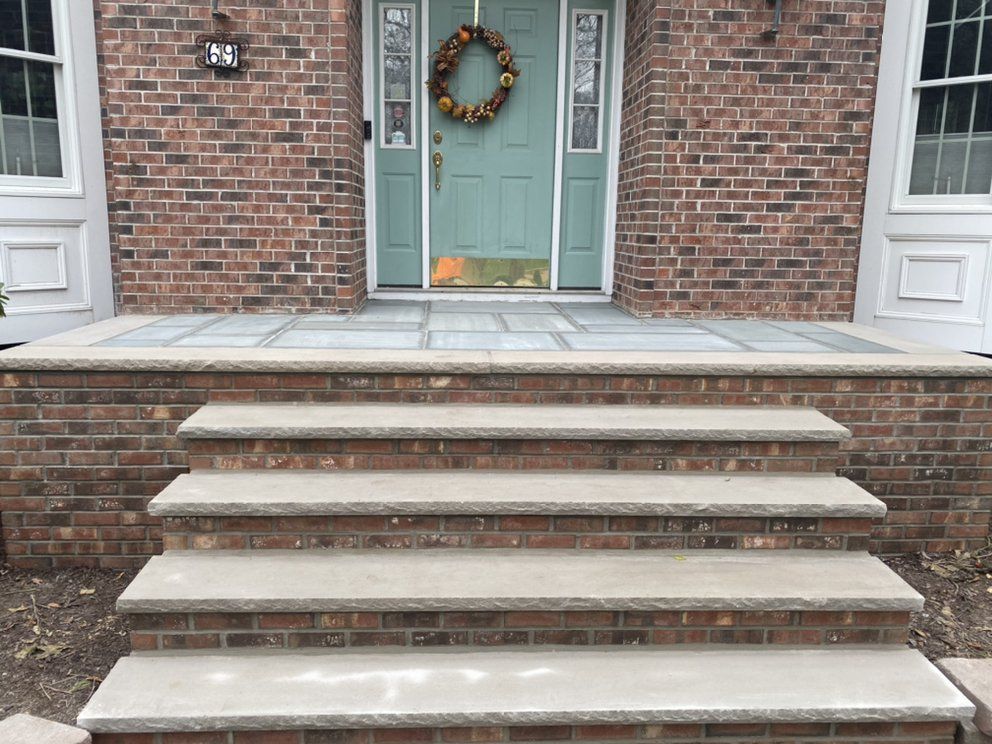A brick house with a blue door and steps