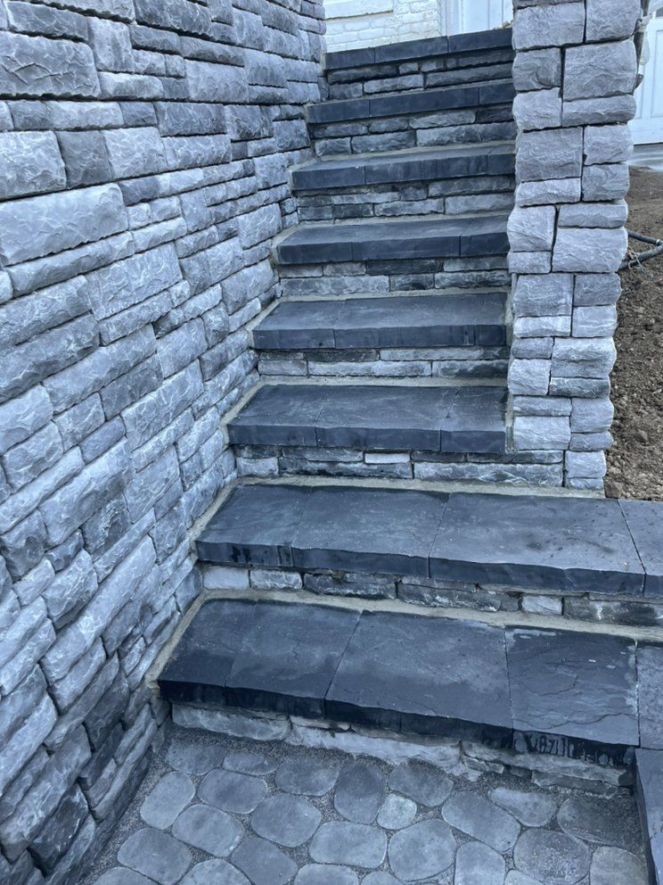 A set of stairs leading up to a stone wall.