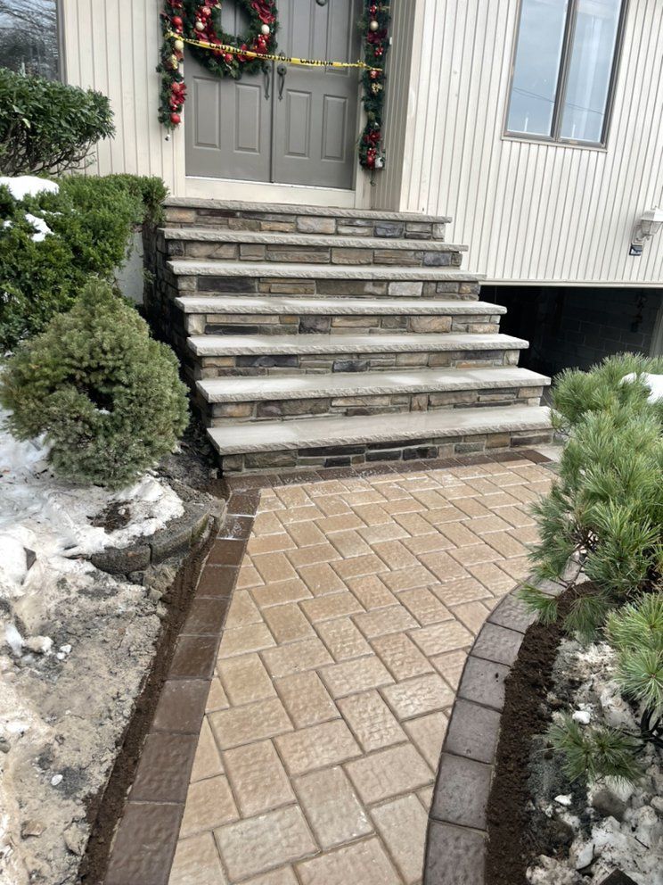 A stone walkway leading to the front steps of a house.
