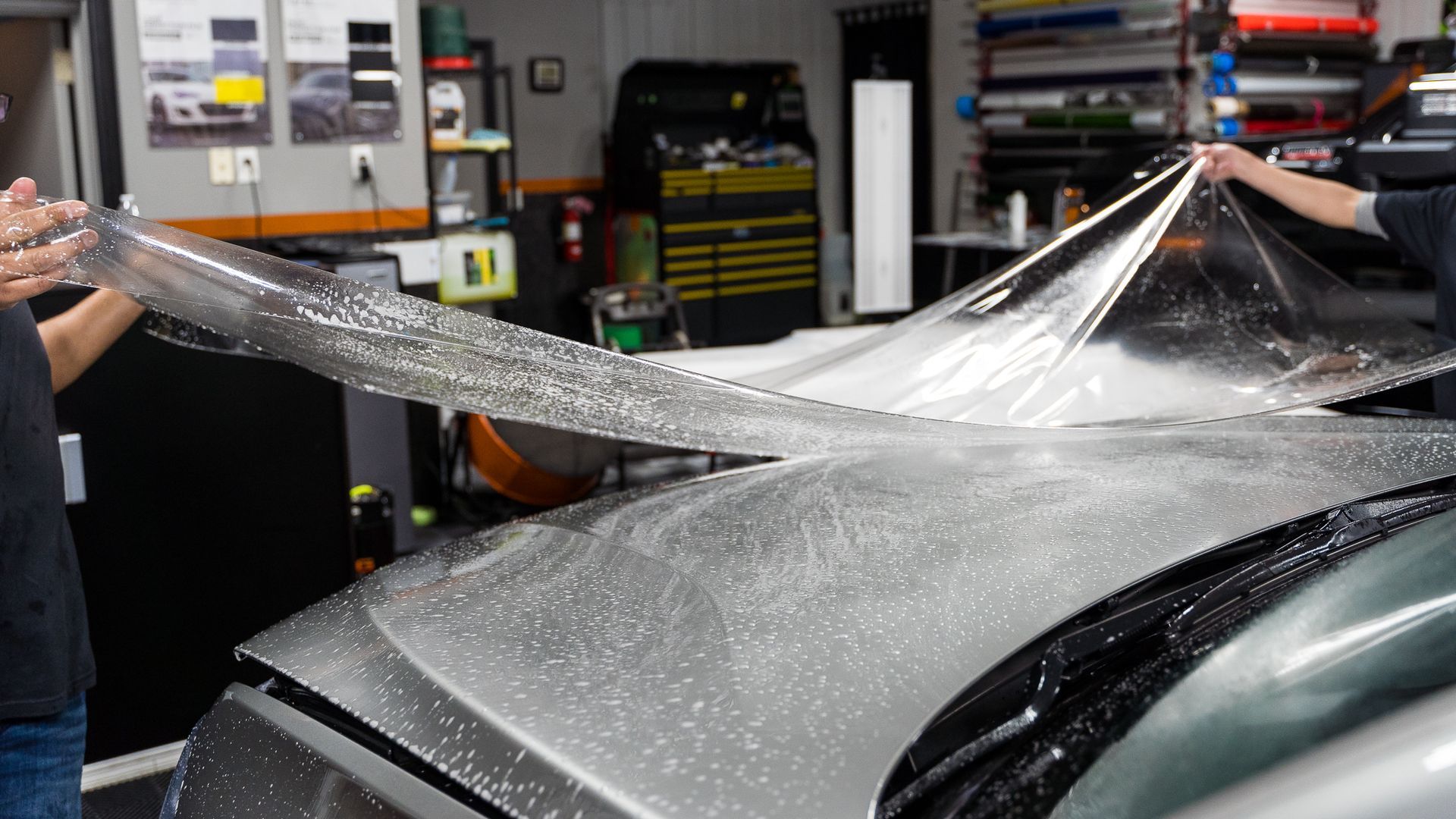 A man is wrapping a car with Paint Protection Film