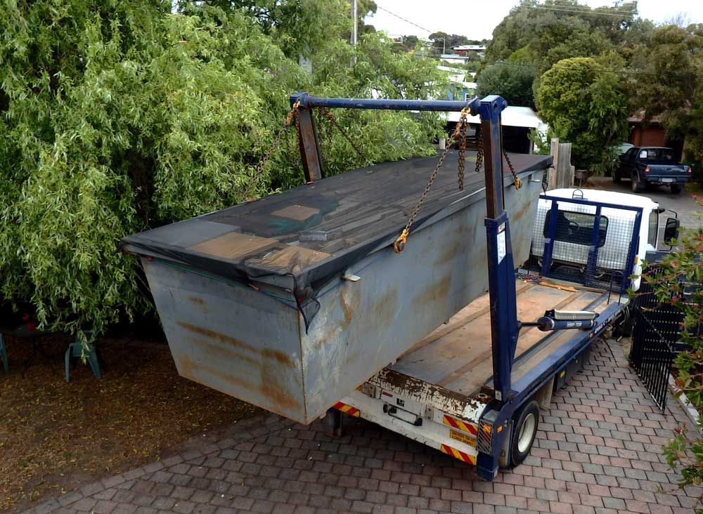 A Dumpster is Sitting on the Back of a Tow Truck — Handi Skips in Bohle, QLD