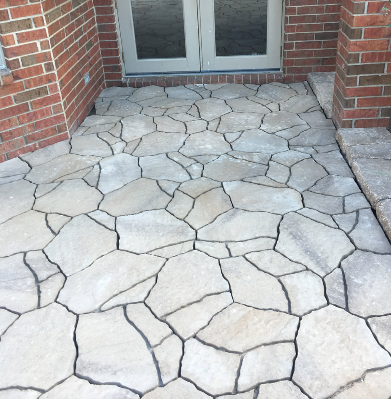 A stone walkway in front of a brick building