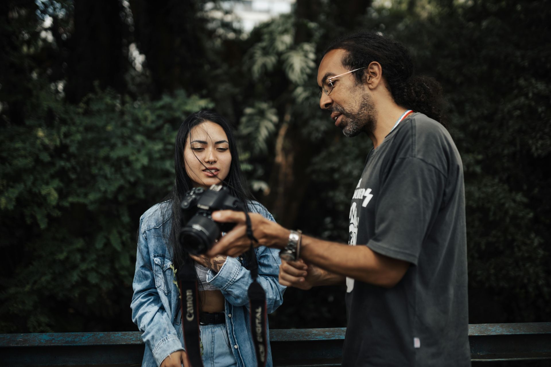 A man is teaching a woman how to use a camera.