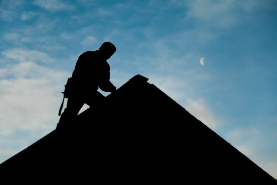 Roofer working on top of the roof to repair damages in a residential property in Wollongong NSW.