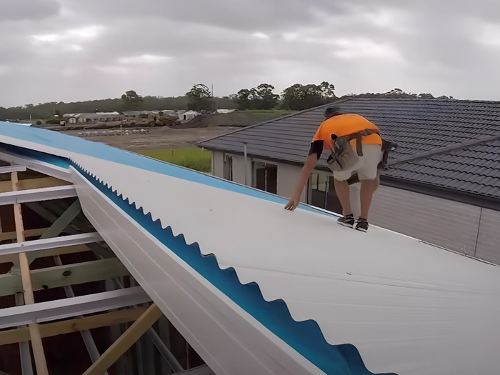 Two professional roof contractors installing tile roof for a new home in Wollongong, NSW.