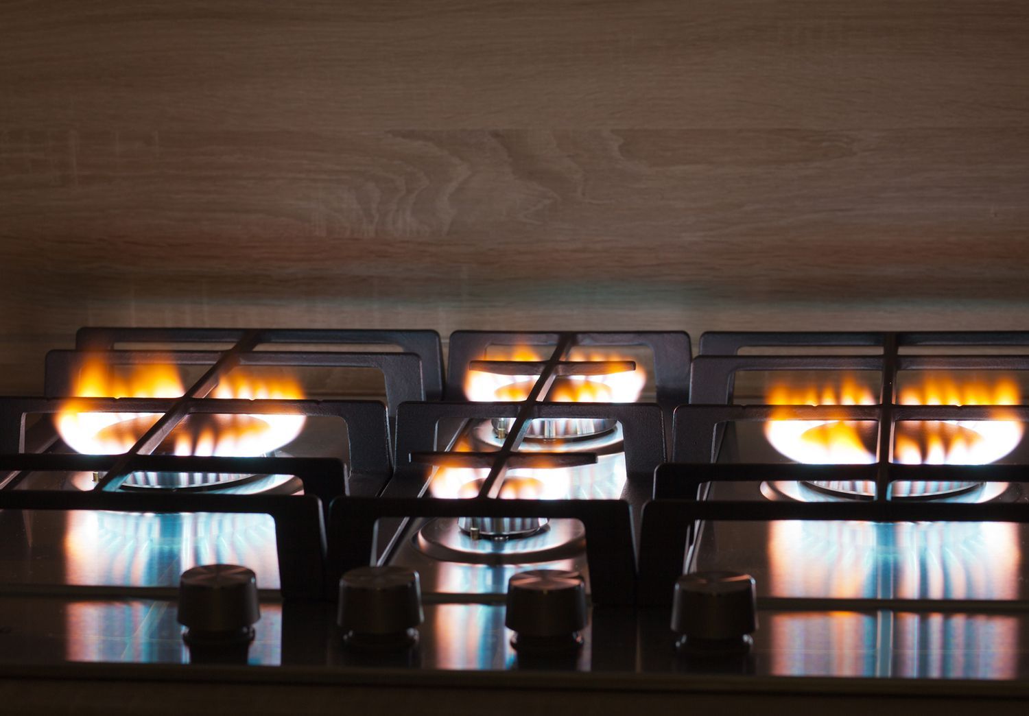 Close-up of a gas stove showcasing residential propane with burners lit and bright flames.