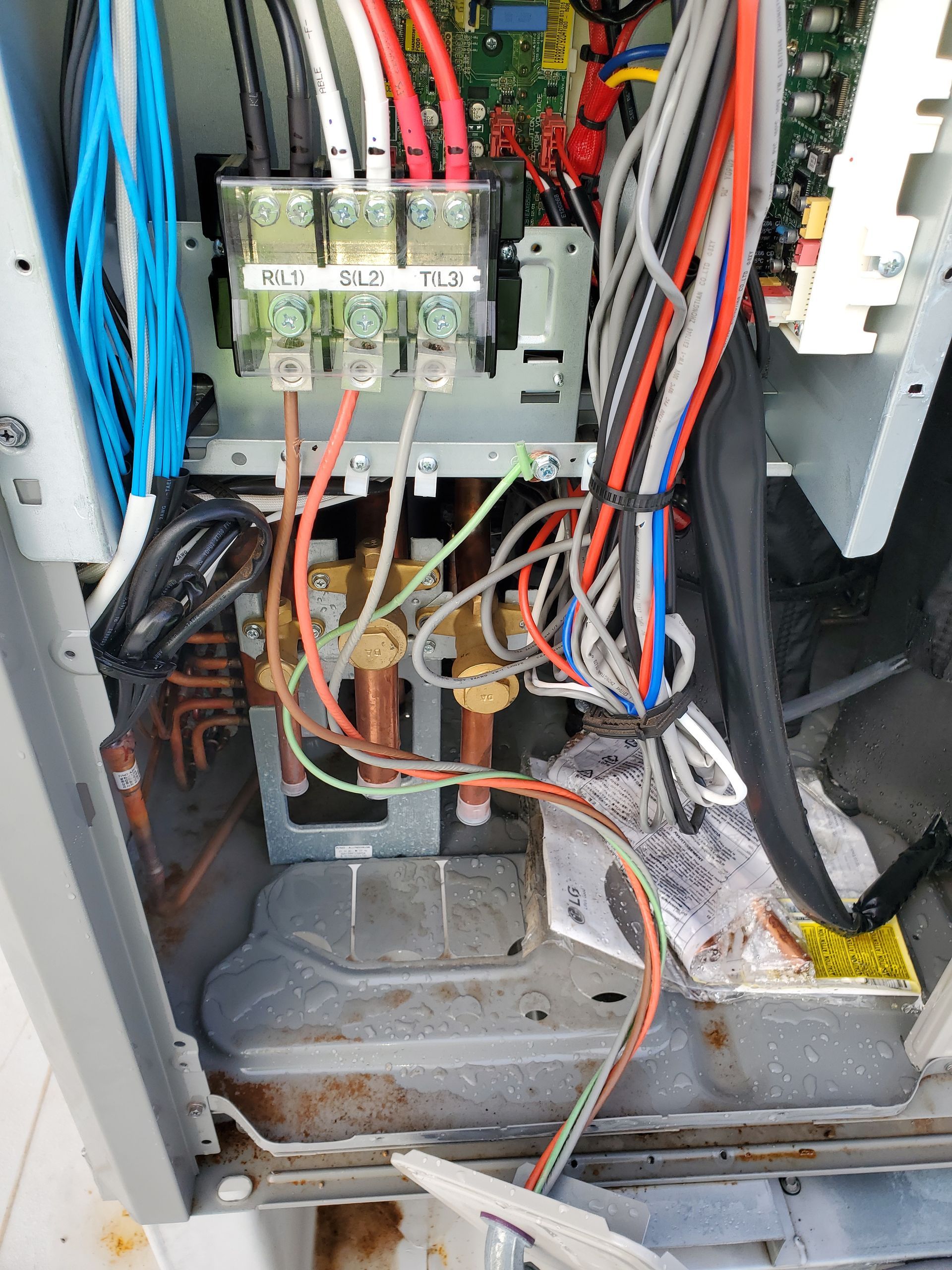 Internal view of electrical wiring and copper tubing in an industrial machine.