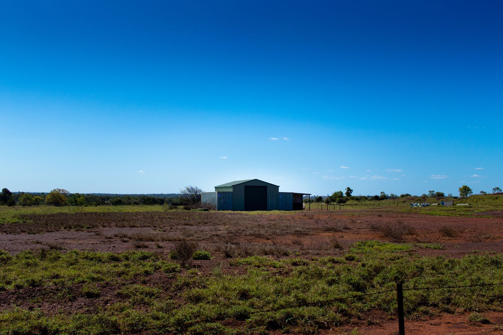 A Small Building in the Middle of a Field With a Blue Sky — Supersonic Couriers In Moranbah, QLD