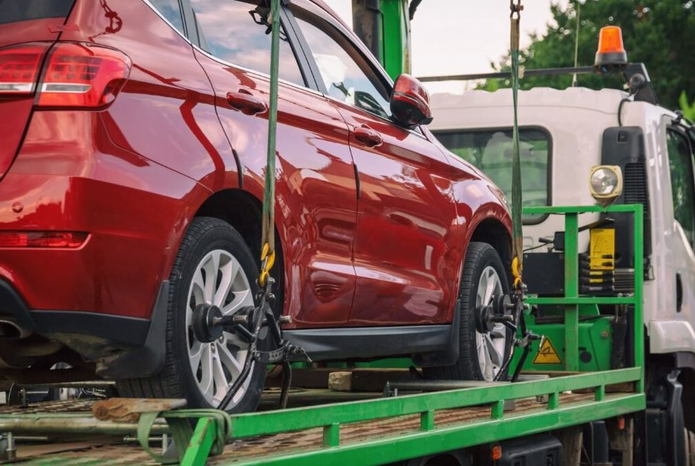 A Red Car is Being Towed by a Tow Truck — Supersonic Couriers In West Mackay, QLD