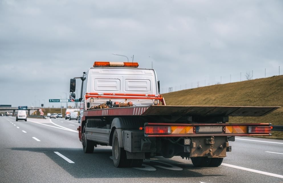 A Tow Truck is Driving Down a Highway — Supersonic Couriers In Emerald, QLD