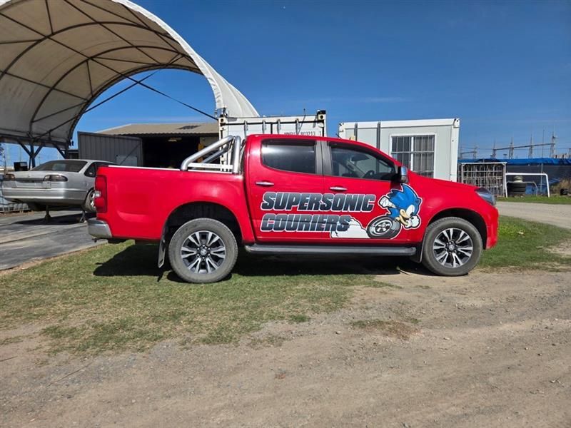 A Semi Truck With a Trailer is Driving Down a Road — Supersonic Couriers In West Mackay, QLD