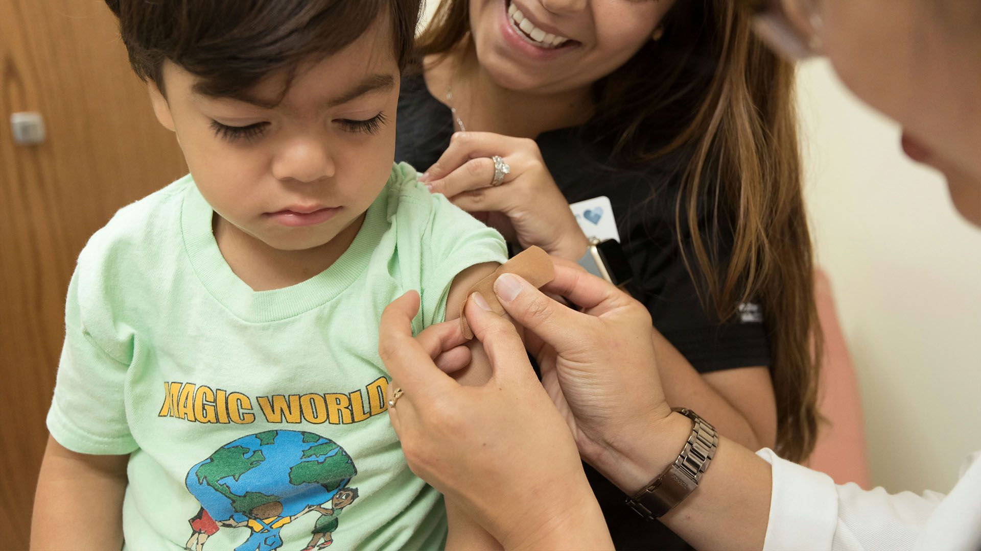 Criança recebendo curativo após aplicação de vacina. foto de CDC