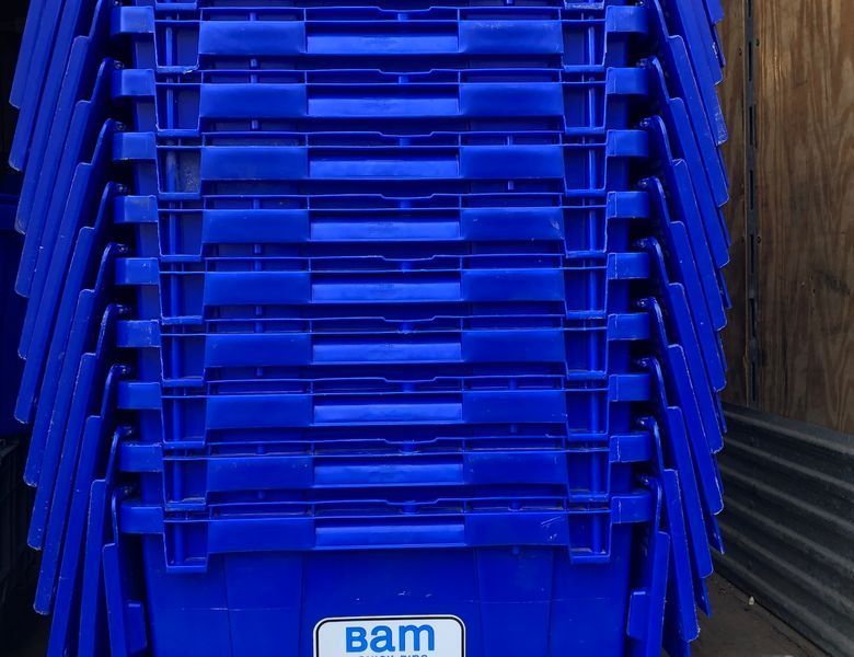 Blue plastic storage bins stacked together. A
