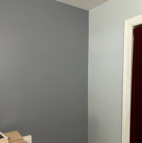 A man wearing a hard hat and safety vest is working on an electrical box.