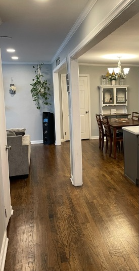 A man is using a drill on a wooden deck.