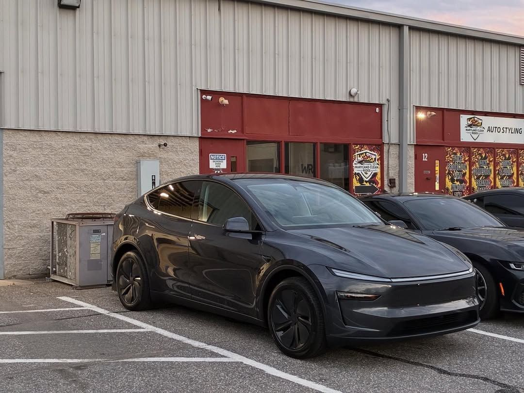 Maroon Dodge Charger in a car wash bay with Maryland Clean Rides sign.