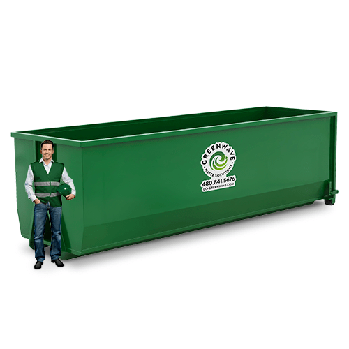 A man is standing next to a green dumpster with the number 30 on it.