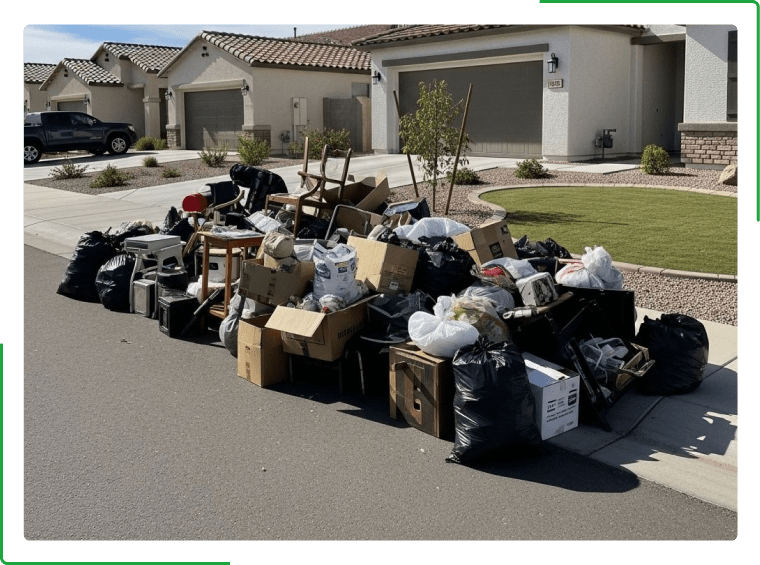 Exterior of a building with garbage bags, a desk, chair, and computer in front of the entrance.