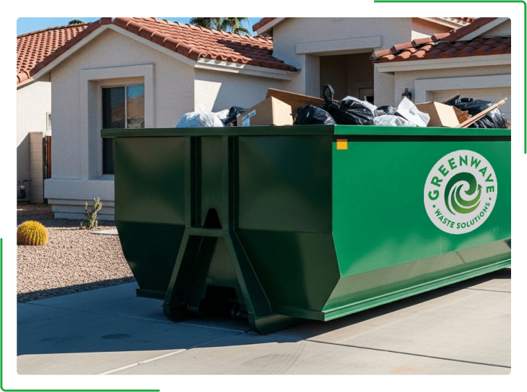A green dumpster filled with cardboard boxes is sitting on the side of the road.