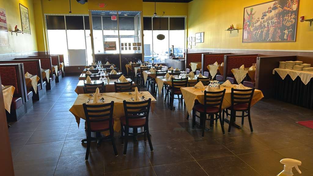 Restaurant interior with tables set for dining, yellow walls.