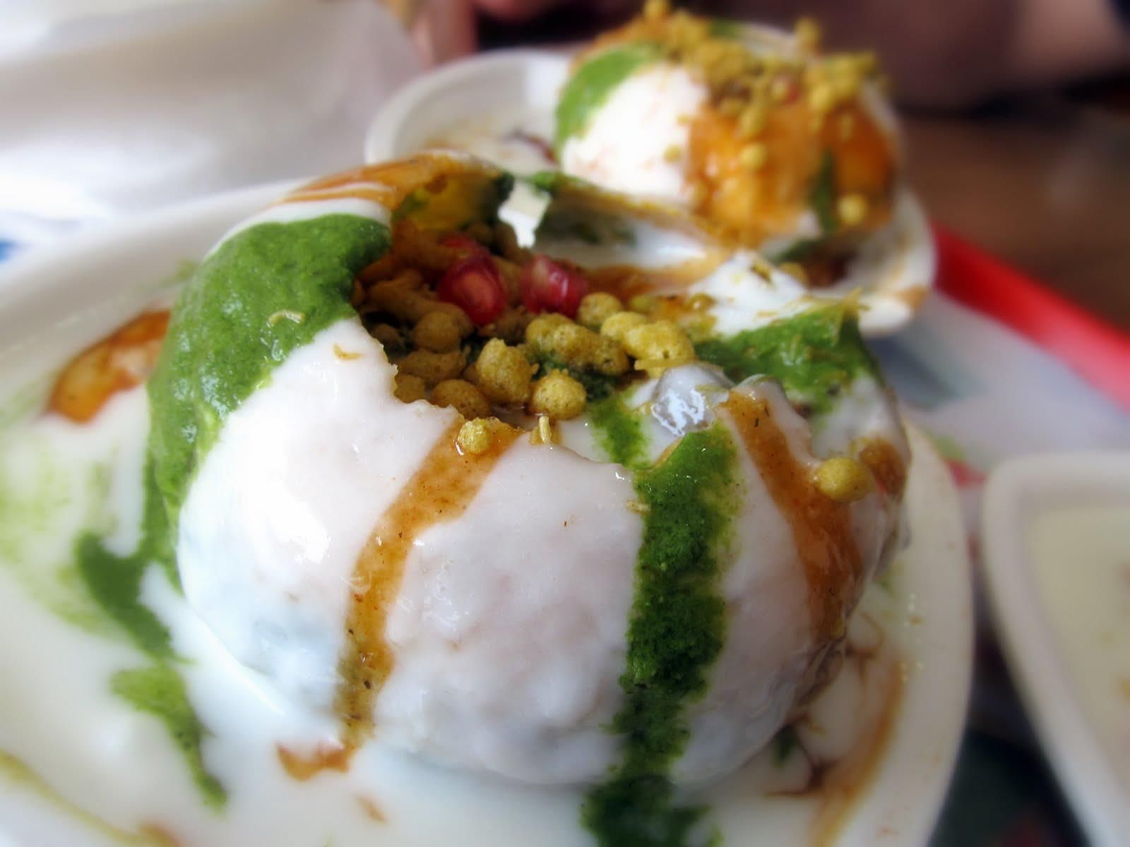 Dining room with yellow walls, tables set with white linens, and chairs.