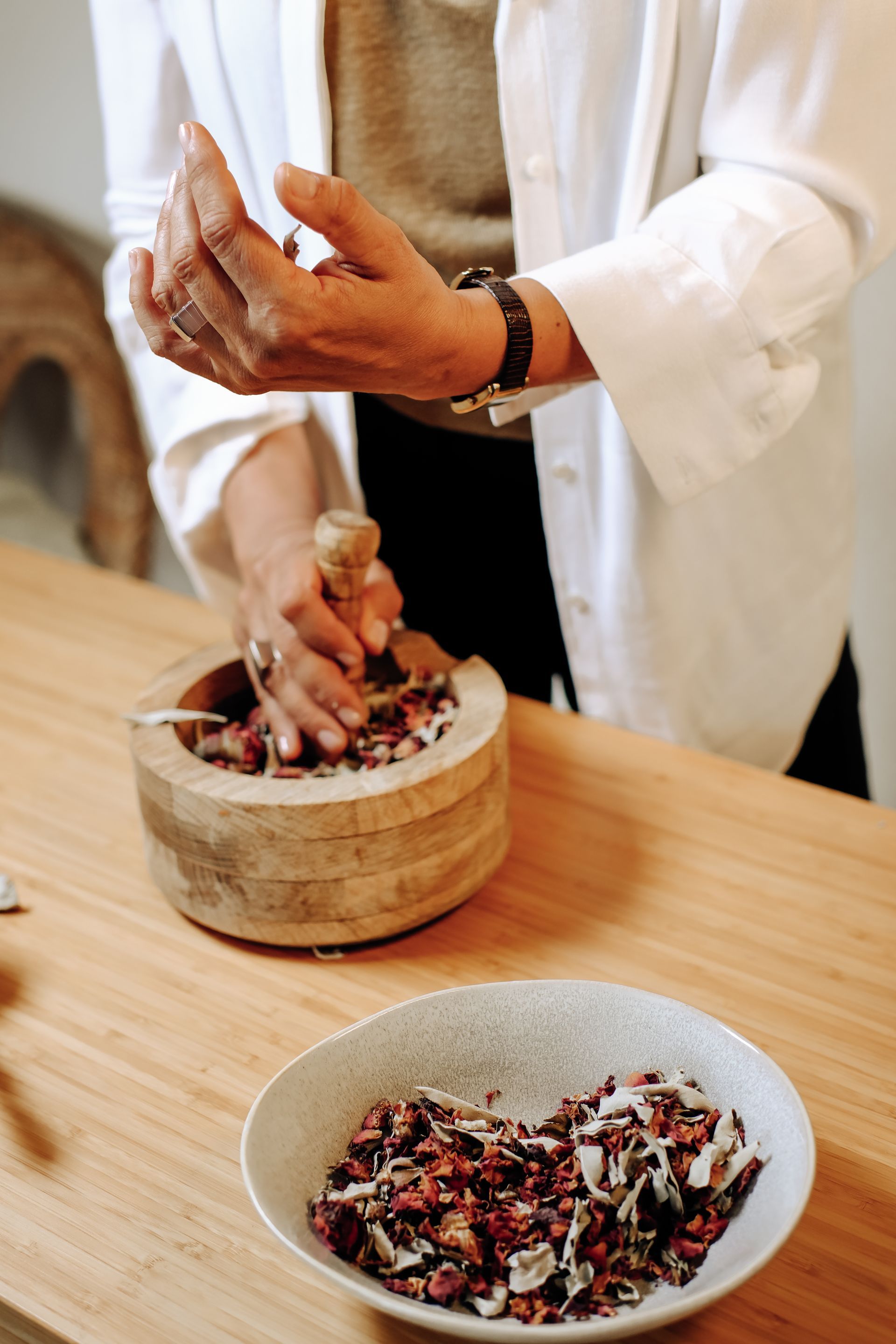 Pessoa moendo ingredientes com um pilão e um almofariz, 