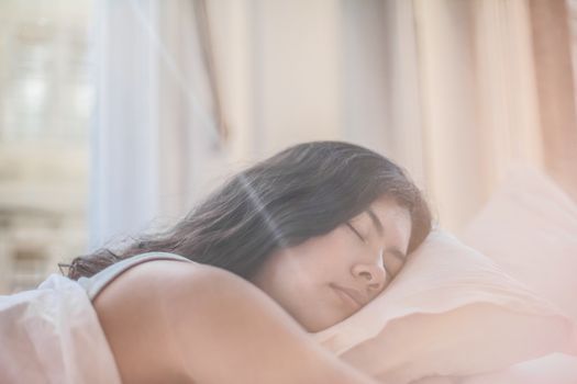 Mulher serena a descansar junto a uma janela com luz natural
