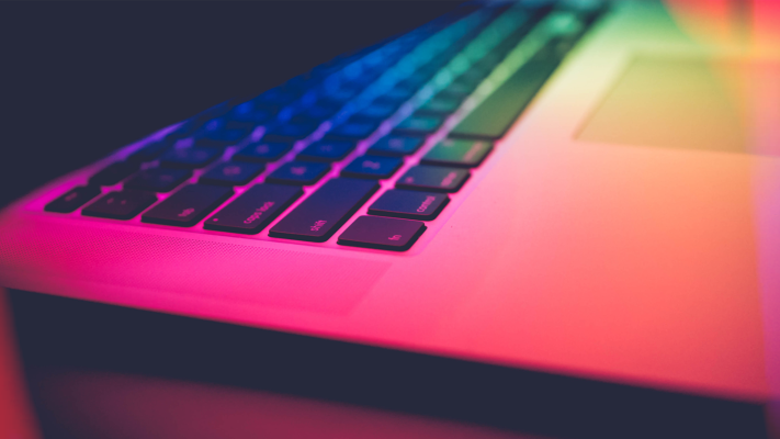 a close up of a rainbow colored laptop keyboard