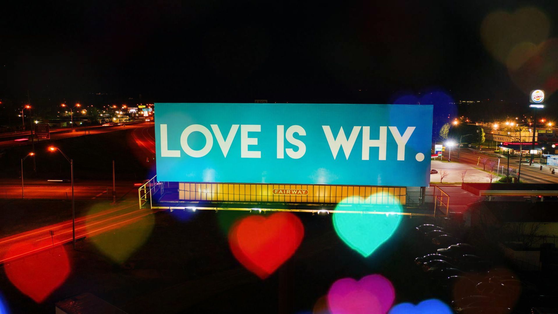 A billboard that says love is why on it