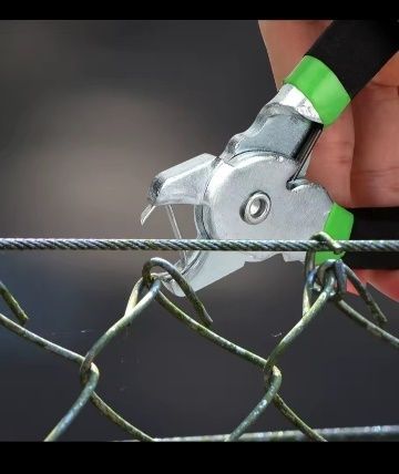 Mano que utiliza alicates para sujetar el alambre a una cerca de alambre de cadena.