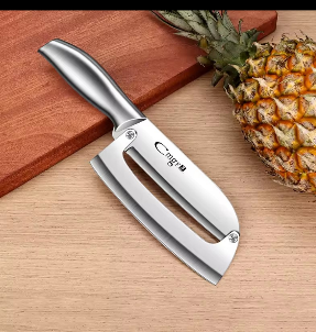 Cuchillo especial junto a una piña sobre una superficie de madera.