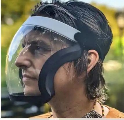 Hombre con protector facial transparente. Diadema blanca y soporte negro a los lados.