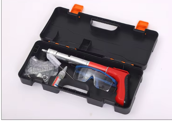 Maletín de herramientas negro abierto con una pistola de calafateo roja, tubos y accesorios en su interior.