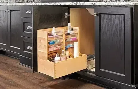 Open kitchen cabinet with pull-out organizer holding jars and bottles