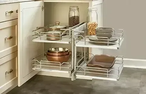 Pull-out kitchen cabinet organizers with metal wire shelves holding pots, bowls, and jars.