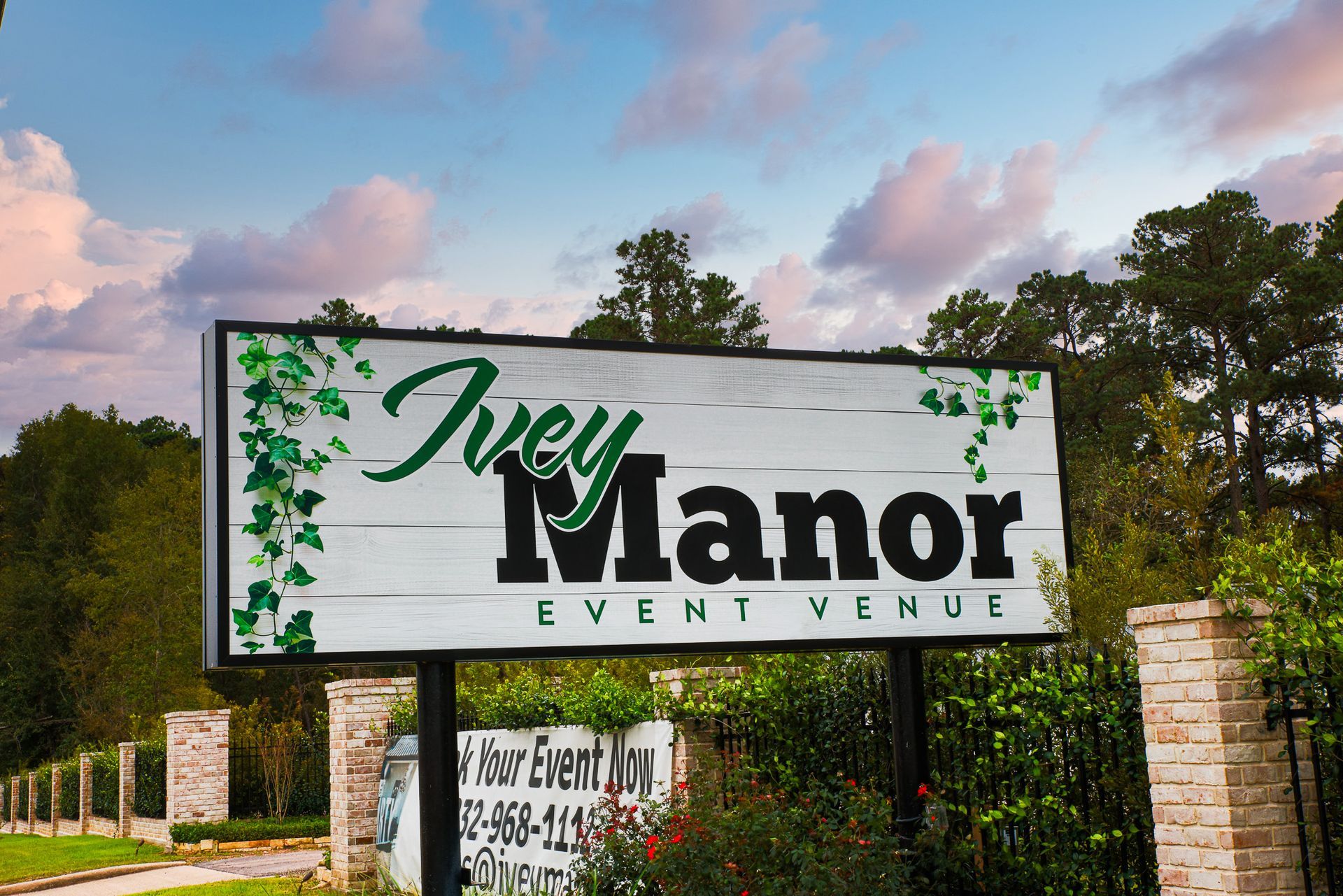 Sign for Ivey Manor Event Venue with green ivy on a white wood-look background.