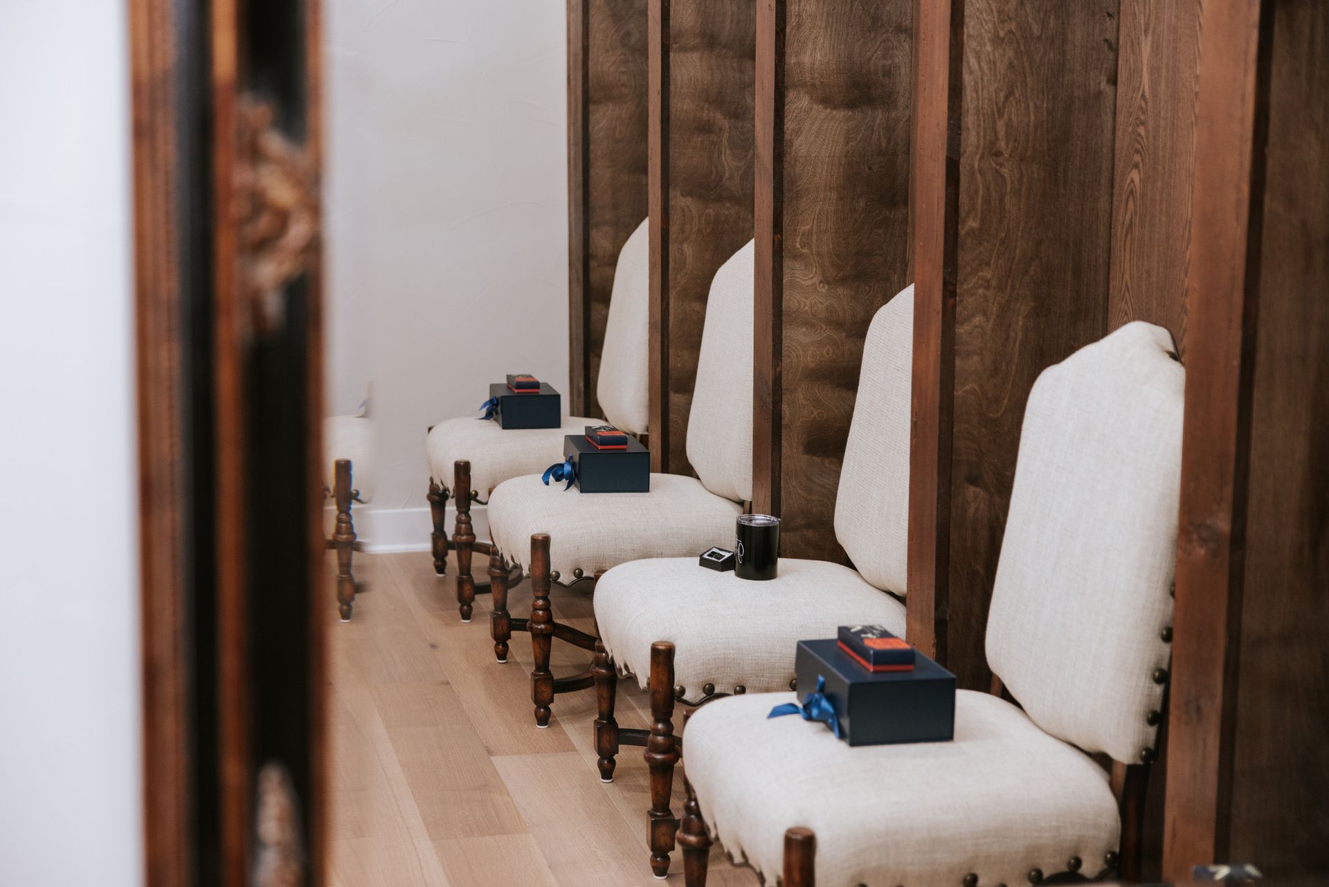 Row of chairs with boxes and dividers in a wooden-paneled room.