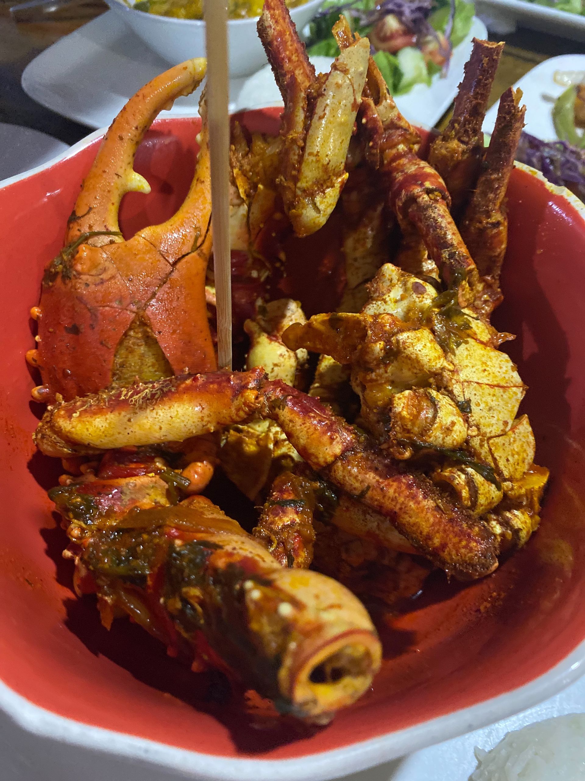 Red bowl of cooked crab with creole spices 