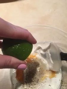  lime over a bowl of sauce.