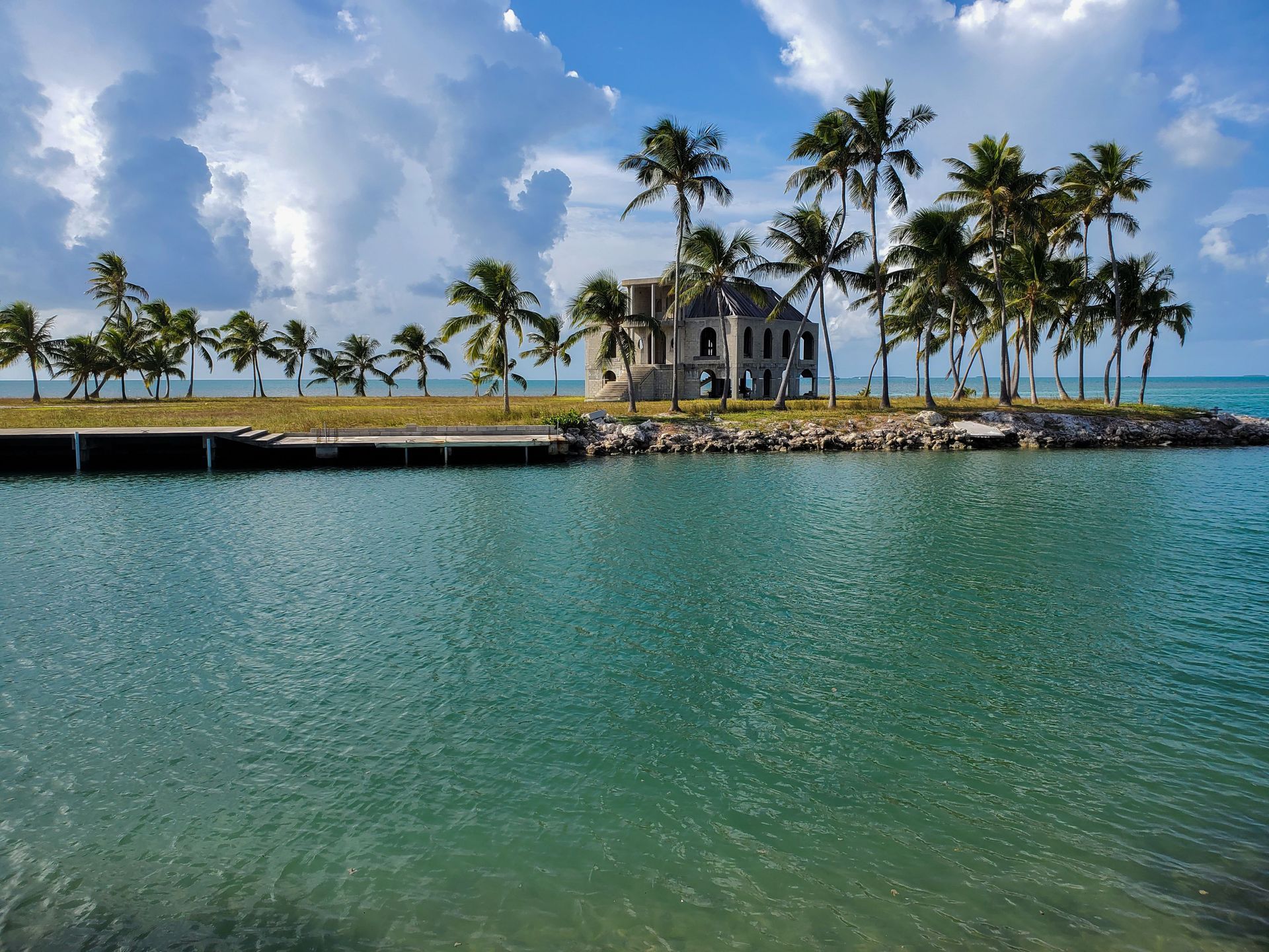 Florida Keys with palm trees, a small white chapel, and turquoise water under a blue sky
