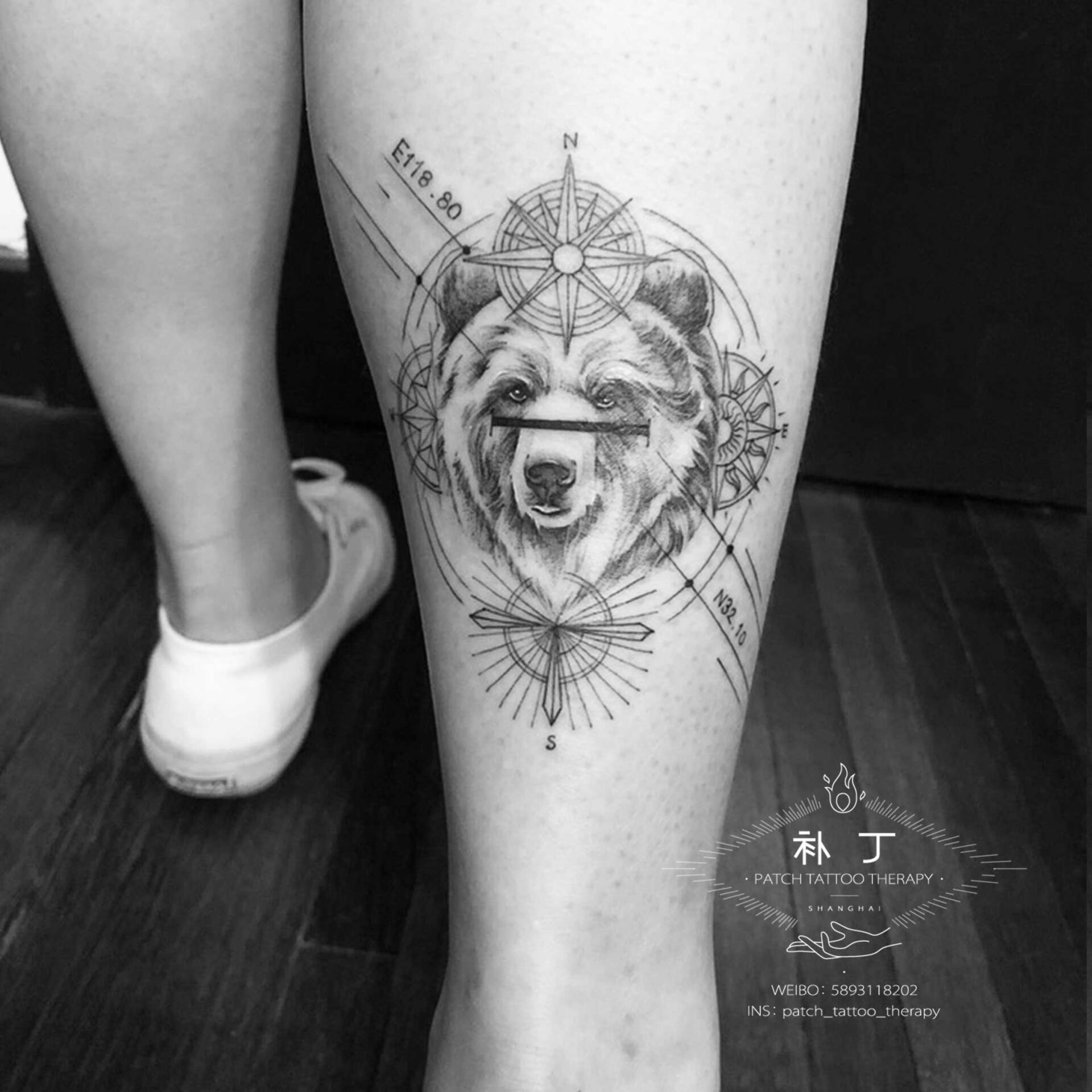 Calf tattoo of a grizzly bear with compass and text in geometric style designed by Jingxi Gu