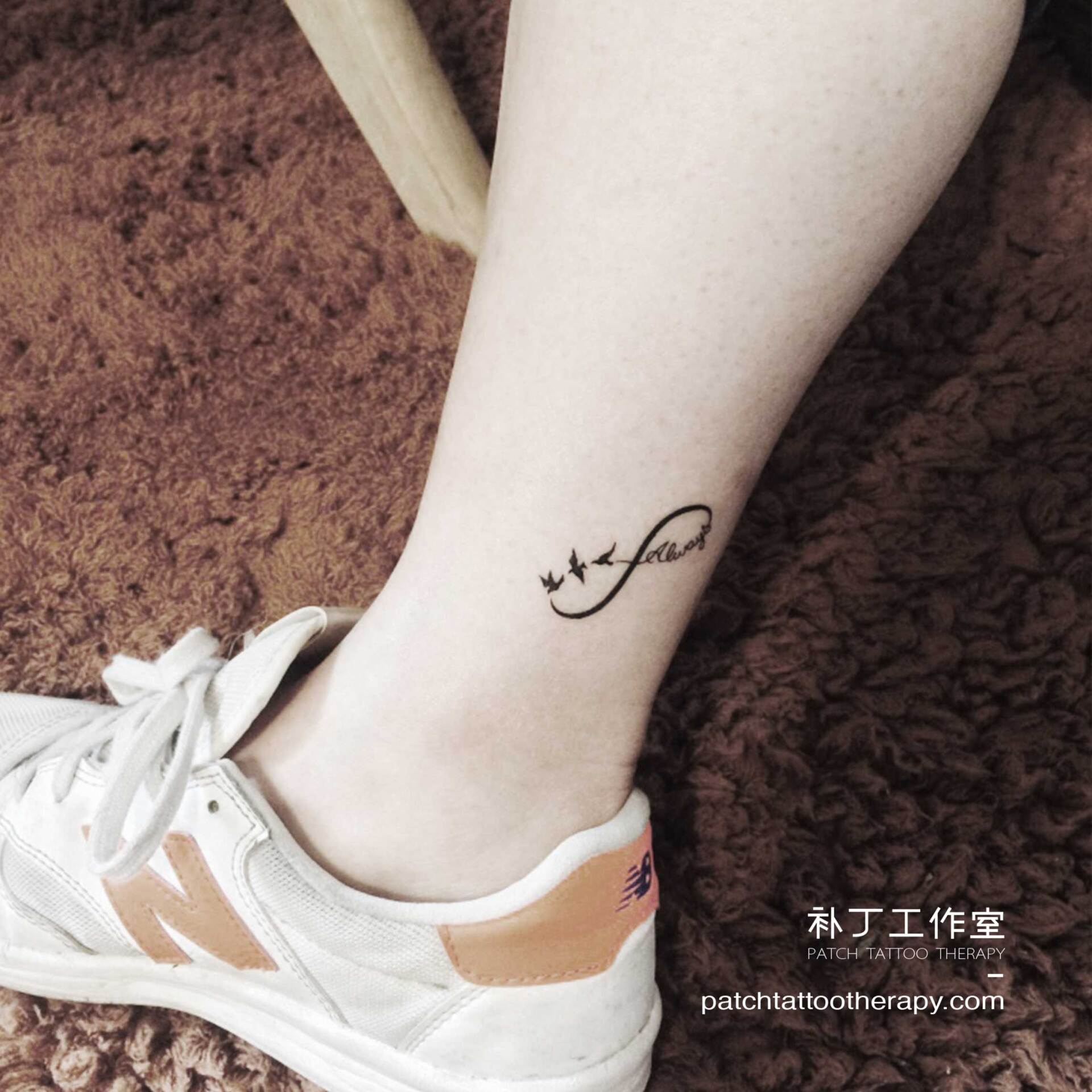 Ankle tattoo of a simple infinity design featurings birds and the text 