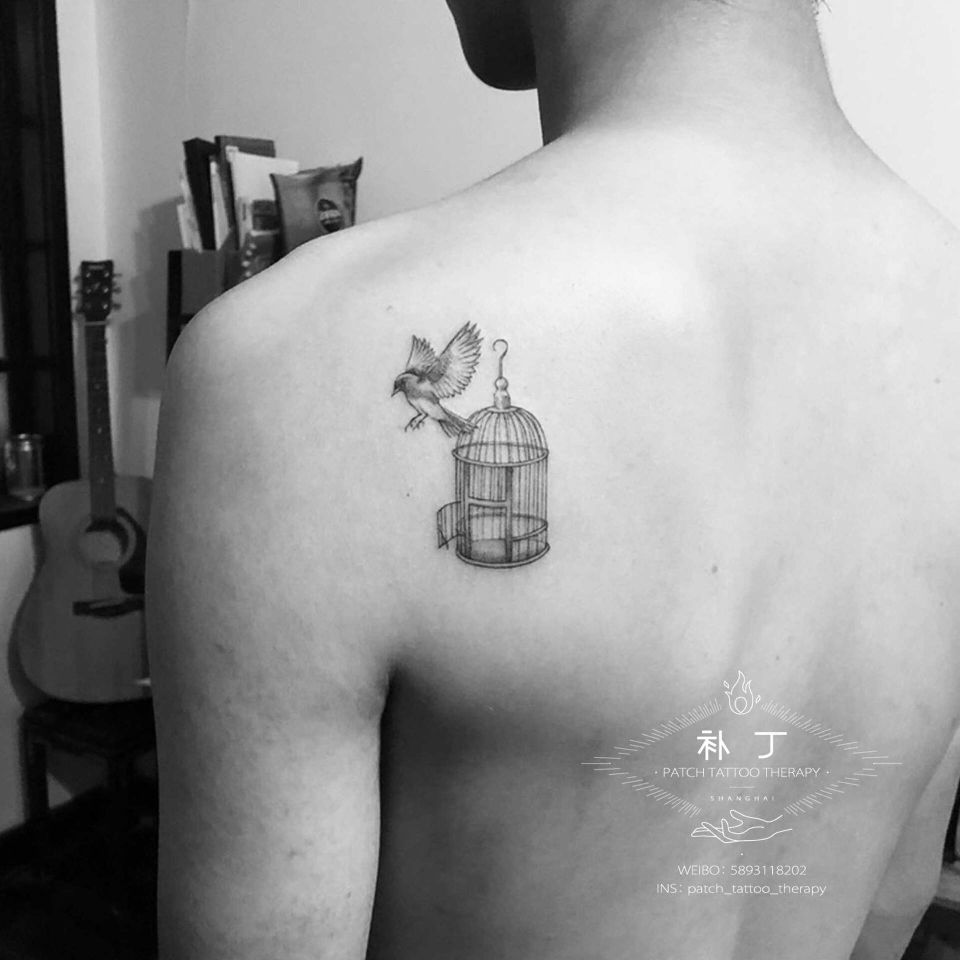Back tattoo of a bird flying out of a cage in micro mini style designed by Jingxi Gu at Patch Tattoo Therapy